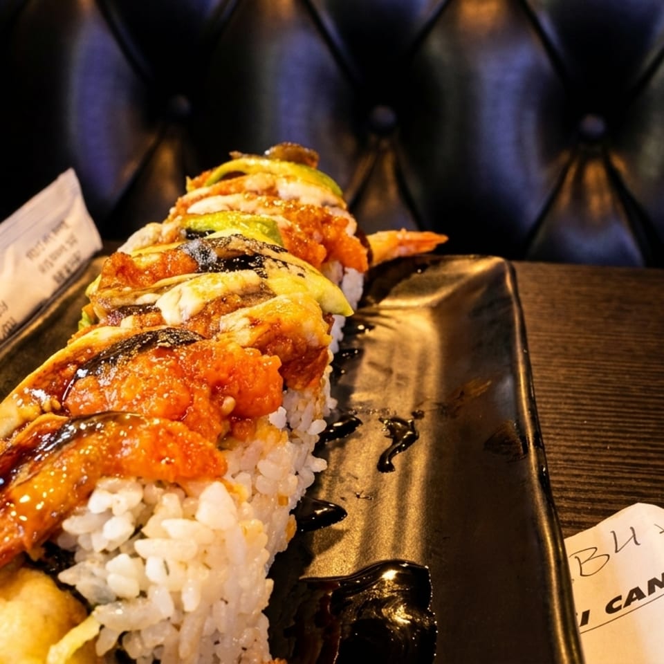 Eel and avocado sushi roll with roe drizzled with sauce
